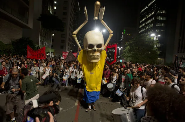 Hundreds of demonstrators protest against money spent on the World Cup preparations in Sao Paulo, Brazil, Thursday, May 15, 2014. Protesters and police clashed Thursday, as demonstrations against the World Cup and rallies calling for improved public services erupted in several Brazilian cities. (Photo by Andre Penner/AP Photo)