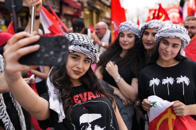 Supporters of the Lebanese Communist party take a selfie, as they march during a demonstration to mark International Labor Day or May Day, in Beirut, Wednesday, May 1, 2024. Despite the tense situation and ongoing clashes on Lebanon's border with Israel over the past seven months, hundreds of protesters marched through Beirut's streets to mark International Workers' Day. (Photo by Hussein Malla/AP Photo)