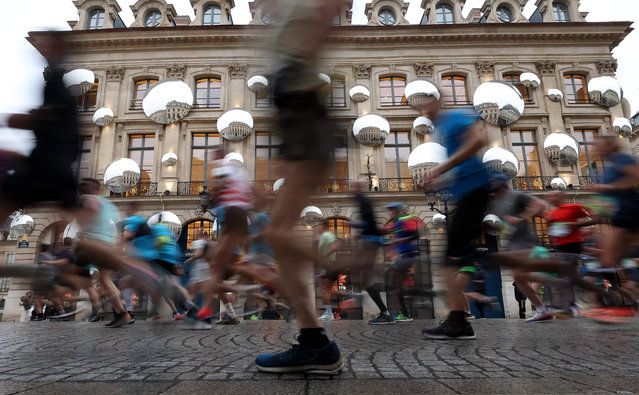 Runners compete during the 46th edition of the Paris Marathon, 42,195 km, in Paris on April 2, 2023. The 42,195 km-route kicked off on the iconic Champs Elysees heading through the Bois de Vincennes park and along the Seine river, before looping around the Bois de Boulogne and ending near the Arc de Triomphe. (Photo by Franck Fife/AFP Photo)