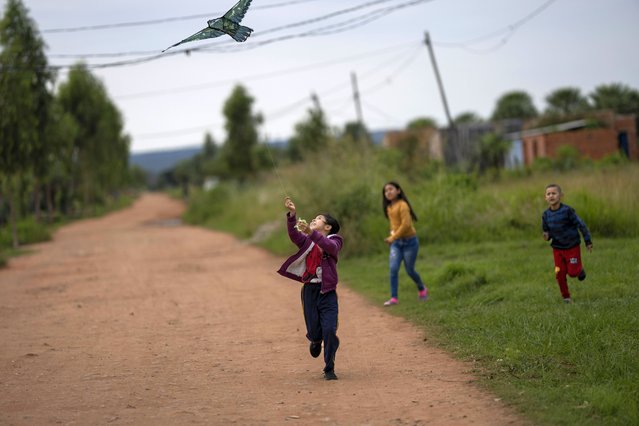 Jenifer Romero flies a kite in the neighborhood Barcelona, on the outskirts of Asuncion, Paraguay, July 6, 2024. (Photo by Rodrigo Abd/AP Photo)