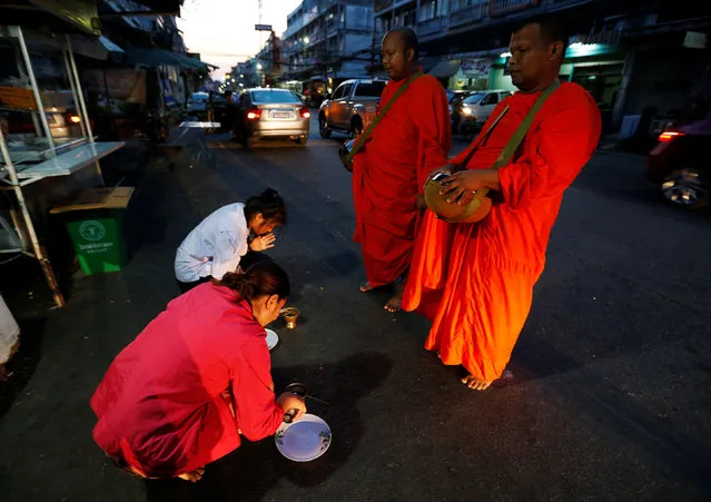Buddhist monks receive food from people in Nonthaburi province, on the outskirts of Bangkok, Thailand February 8, 2017. (Photo by Chaiwat Subprasom/Reuters)