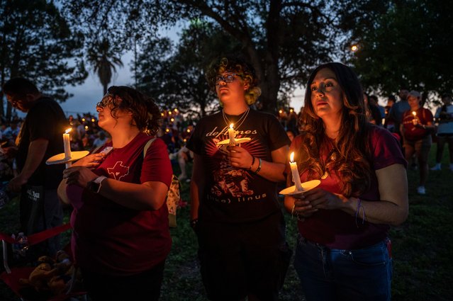 From left; Valeria Zamarripa, Jillian Zamarripa and Venesa Davilo hold candles during a vigil at the Uvalde Ampitheater on Wednesday, May 24, 2023 in Uvalde, TX. The community gathered to remember those that were lost in a shooting last year at Robb Elementary that took the lives of 19 students and 2 teachers. (Sergio Flores for The Washington Post)