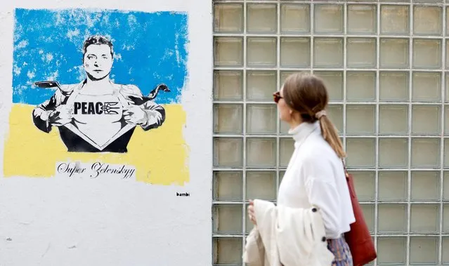 A woman walks past artwork depicting Ukrainian president Volodymyr Zelenskiy by artist Bambi as Russia's invasion of Ukraine continues, London, Britain, March 24, 2022. (Photo by Peter Cziborra/Reuters)