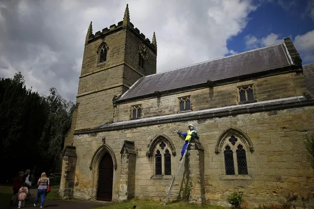 Visitors walk past a scarecrow on St John's Church titled “Help” during the Scarecrow Festival in Heather, Britain July 29, 2015. (Photo by Darren Staples/Reuters)