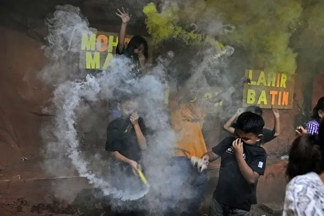 Young boys light smoke bombs as they celebrate the eve of Eid al-Fitr, the holiday marking the end of the holy fasting month of Ramadan, in Jakarta, Indonesia, Sunday, May 1, 2022. (Photo by Dita Alangkara/AP Photo)
