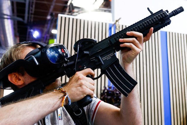 A man operates a virtual reality VR machine gun at the Viva Technology conference dedicated to innovation and startups at Porte de Versailles exhibition center in Paris, France on June 15, 2023. (Photo by Gonzalo Fuentes/Reuters)