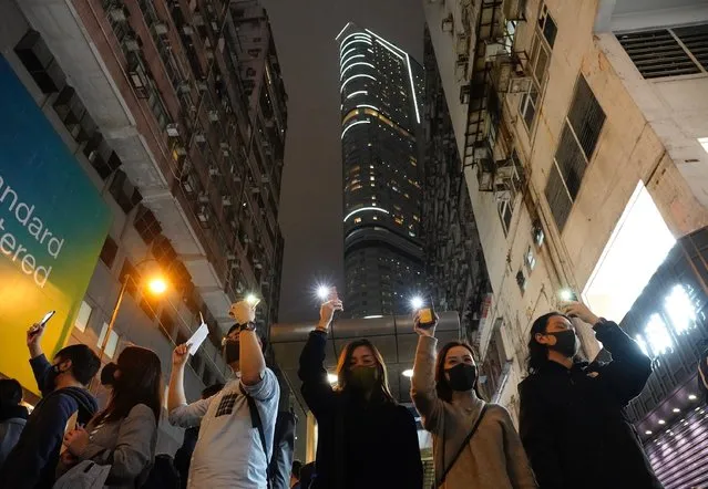 People raise their cellphones lights as they form a human chain on New Year's eve in Hong Kong, Tuesday, December 31, 2019. Months of pro-democracy protests have brought “sadness, anxiety, disappointment and even rage”, the city’s leader Carrie Lam said in a News Year’s address Tuesday. Protests that began in June over a proposed extradition law have spread to include demands for more democracy and other grievances. (Photo by Vincent Yu/AP Photo)