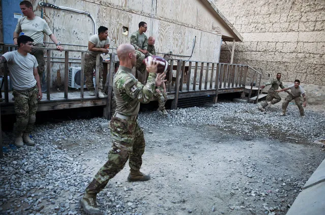U.S. Army soldiers from Charlie Company, 2-14 Infantry Regiment, 2nd Brigade, 10th Mountain Division play football in Forward Operating Base (FOB) Connolly in Nangarhar province, east of Kabul, Afghanistan, Wednesday, August 5, 2015. (Photo by Massoud Hossaini/AP Photo)