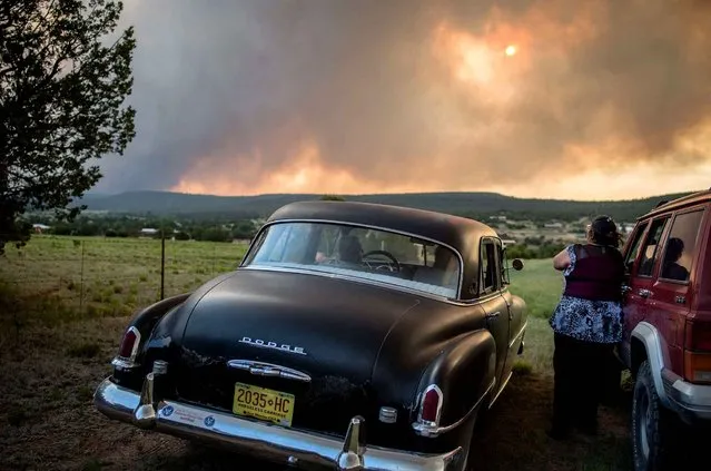 Residents of the town, Chilili, along state road 337 watch as the Dog Head Fire inches closer to their town, southeast of Albuquerque, N.M., Wednesday June 15, 2016. Authorities don't have a containment estimate yet for a wildfire burning in the Manzano Mountains southeast of Albuquerque but say good weather helped firefighters attack the fire overnight. The so-called “Dog Head Fire” in part of the Cibola National Forest east of Los Lunas started Tuesday and grew to over a square mile by Wednesday morning after its growth slowed overnight. (Photo by Roberto E. Rosales/The Albuquerque Journal via AP Photo)