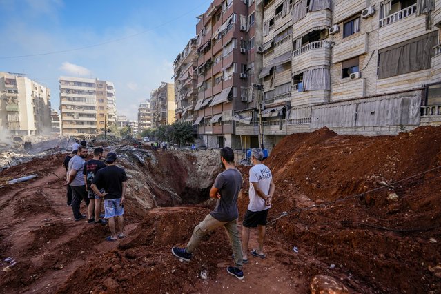 People gather at the site of the assassination of Hezbollah leader Hassan Nasrallah in Beirut's southern suburbs, Sunday, September 29, 2024. (Photo by Hassan Ammar/AP Photo)