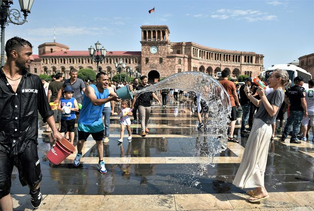 People splash each other in downtown Yerevan, Armenia during an annual Vardavar holiday on July 16, 2023. Vardavar is a traditional Armenian water festival, with people drenching each other, dating back to pagan times. The ancient festival is traditionally associated with the goddess Astghik, who was the goddess of water, beauty, love, and fertility. (Photo by Karen Minasyan/AFP Photo)