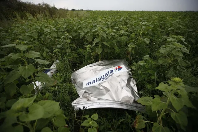 Debris from a Malaysian Airlines Boeing 777 that crashed on Thursday lies on the ground near the village of Rozsypne in the Donetsk region July 18, 2014. World leaders demanded an international investigation into the shooting down of Malaysia Airlines Flight MH17 with 298 people on board over eastern Ukraine in a tragedy that could mark a pivotal moment in the worst crisis between Russia and the West since the Cold War. (Photo by Maxim Zmeyev/Reuters)