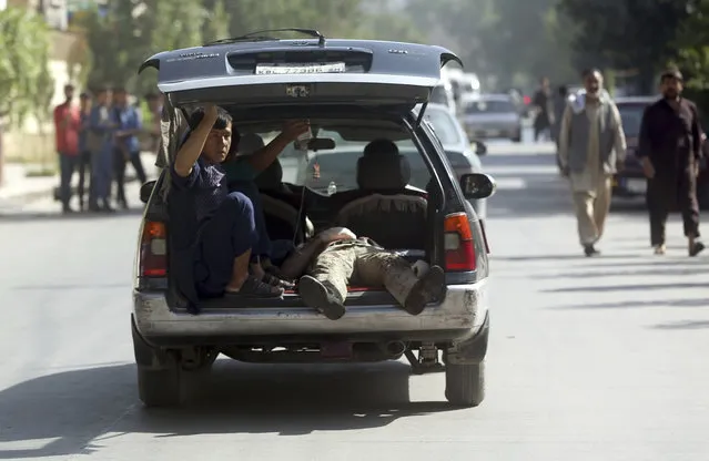 A wounded man is carried on the way to a hospital near the site of a suicide attack in Kabul, Afghanistan, Monday, July 24, 2017. A suicide bomber rammed his car packed with explosives into a bus carrying government employees in the Afghan capital. (Photo by Massoud Hossaini/AP Photos)