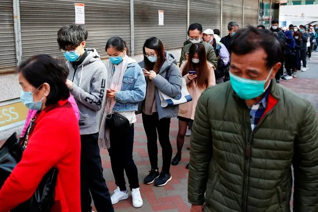 Customers queue to buy facial masks to prevent an outbreak of a new coronavirus, in Hong Kong, China on January 31, 2020. (Photo by Tyrone Siu/Reuters)
