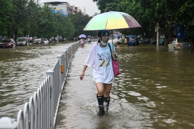A resident walks on a flooded street after heavy rains in Shaoguan in China's southern Guangdong province on June 21, 2022. (Photo by AFP Photo/China Stringer Network)