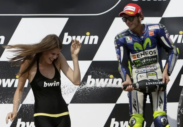Yamaha MotoGP rider Valentino Rossi of Italy sprays champagne to a grid girl after finishing third in the Czech Grand Prix in Brno, Czech Republic, August 16, 2015. (Photo by David W. Cerny/Reuters)