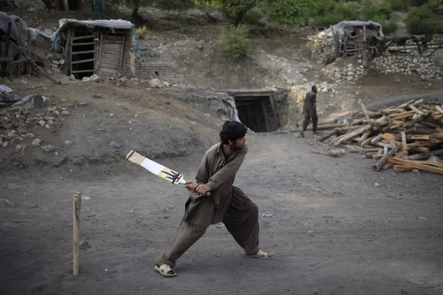 A miner plays cricket in the evening at a coal field in Choa Saidan Shah, Punjab province, May 5, 2014. (Photo by Sara Farid/Reuters)