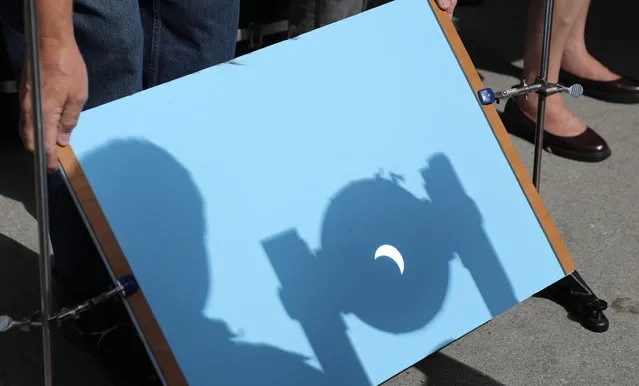 A telescope projects an image of the solar eclipse during a viewing party sponsored by the University of California-Irvine Department of Physics and Astronomy in Irvine, California, USA, 21 August 2017. Hundreds gathered for the partial eclipse here in Southern California. The 21 August 2017 total solar eclipse will last a maximum of 2 minutes 43 seconds and the thin path of totality will pass through portions of 14 US states, according to the National Aeronautics and Space Administration (NASA). (Photo by Eugene Garcia/EPA)