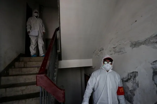 Workers in protective suits conduct a door-to-door search to inspect residents in Wuhan, February 17, 2020. (Photo by Reuters/China Daily)