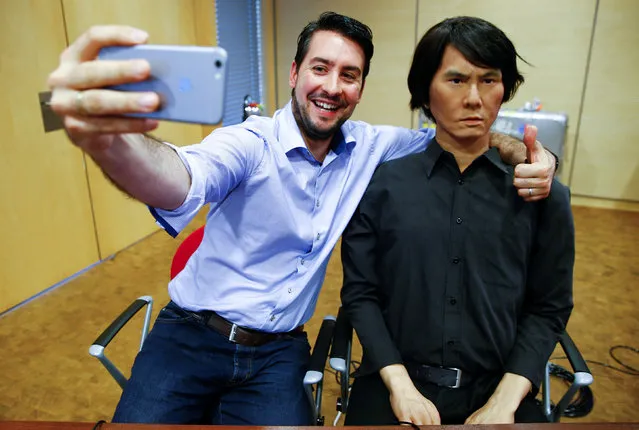 An employee of Germany's biggest retailer Metro AG takes a selfie with HI-4, a life-size humanoid robot, at Metro's headquarters in Duesseldorf, Germany, June 7, 2016. The android, modelled after its Japanese inventor Hiroshi Ishiguro, a professor at Osaka's University, is made of a metal skeleton, plastic skull and silicon skin; and can be used as a human substitute for interaction via a tele-operated control system. (Photo by Wolfgang Rattay/Reuters)
