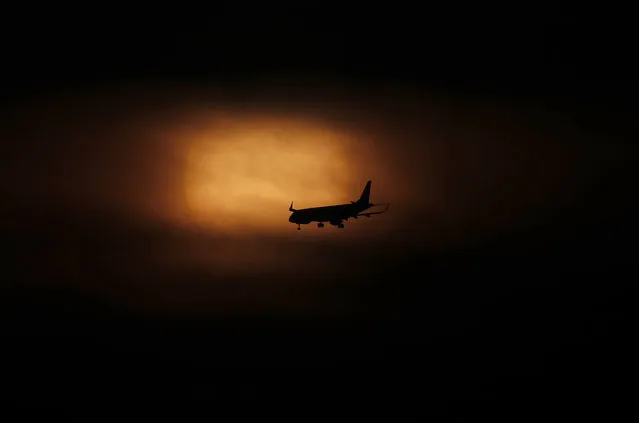 An airplane comes in for its landing as the sun rises in Mexico City, Saturday, March 21, 2020. Many countries in Latin America have taken aggressive measures to deal with the new coronavirus such as closing their borders, dock and airports to foreigners. Mexico, by contrast, has so far taken a “business as usual” attitude. (Photo by Marco Ugarte/AP Photo)