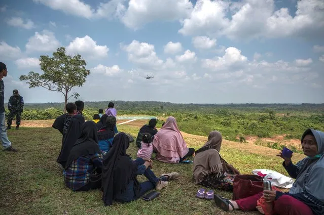 Villagers gather to watch US and Indonesian soldiers taking part in the Super Garuda Shield 2022 joint military exercises in Baturaja, South Sumatra on August 12, 2022. (Photo by Juni Kriswanto/AFP Photo)