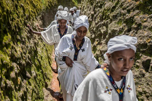Young women walk through the cave of Saint George during Ashenda festival, at Saint George Church, in Lalibela, Ethiopia, on August 22, 2022. (Photo by Amanuel Sileshi/AFP Photo)