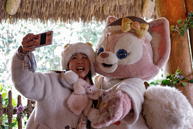 A fan takes a selfie with a performer dressed as the character LinaBell, a pink fox character from the Disney series “Duffy and Friends”, at Shanghai Disneyland, in Shanghai, China on December 23, 2024. (Photo by Tingshu Wang/Reuters)