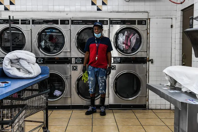 US Gregory Stark, 54, laundry shop employee poses for a picture in Miami, United States, on April 17, 2020 during the COVID-19 coronavirus pandemic. Ahead of May Day on May 1, 2020, AFP portrayed 55 workers defying the novel coronavirus around the world. Gregory Stark feels blessed for having a job and feels obligated because not everybody has a washing machine at home. He feels it's a new world, and not only him but the word that is affected by the new coronavirus. He wears facemask and gloves all day to keep him protected as he helps customers bringing in their clothes from their cars and sorting them out. (Photo by Chandan Khanna/AFP Photo)