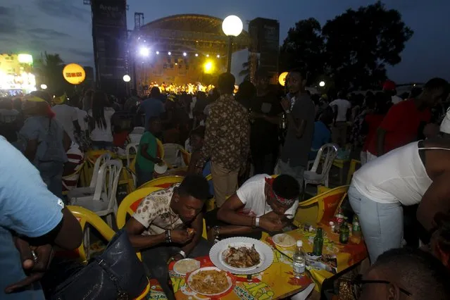 Attendees eat during the Festival des Grillades, in the yard of the Culture Palace of Abidjan, September 5, 2015. (Photo by Luc Gnago/Reuters)
