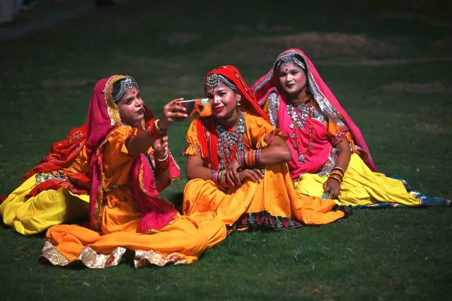 Performers in traditional attire take a selfie at the lawns after the recent inauguration of the newly renovated avenue ‘Central Vista’ in New Delhi on September 10, 2022. (Photo by Sajjad Hussain/AFP Photo)