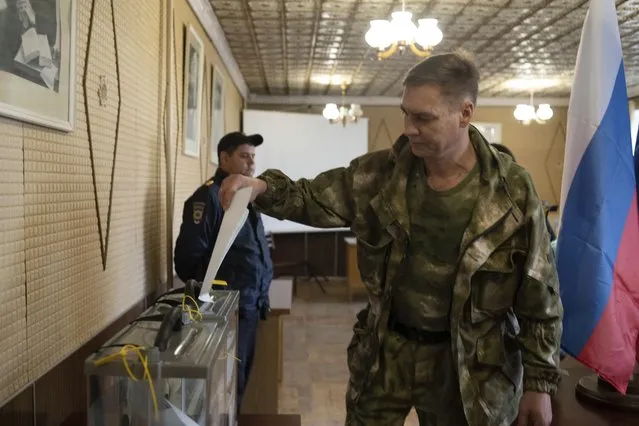 A Luhansk People's Republic serviceman votes in a polling station in Luhansk, Luhansk People's Republic, controlled by Russia-backed separatists, eastern Ukraine, Friday, September 23, 2022. Voting began Friday in four Moscow-held regions of Ukraine on referendums to become part of Russia. (Photo by AP Photo/Stringer)