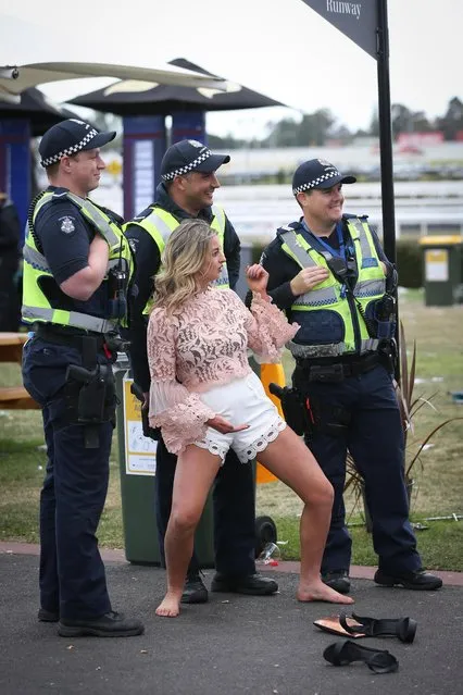This lady gets down with the cops after ditching her heels during Caulfield Cup Day at Caulfield Racecourse on October 21, 2017 in Melbourne, Australia. (Photo by Splash News and Pictures)