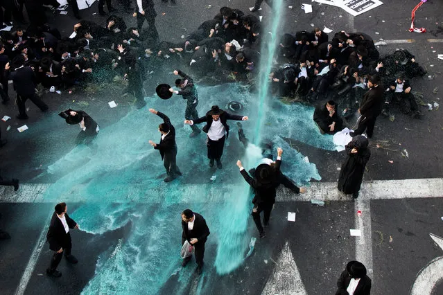 Police use water canon trying to disperse Ultra-Orthodox Jewish demonstrators as they block the main entrance to Jerusalem, during a protest against army recruitment in Jerusalem, Israel, 23 October 2017. The Ultra-Orthodox community in Israel is holding ongoing protest against army recruitment. (Photo by  Abir Sultan/EPA/EFE)
