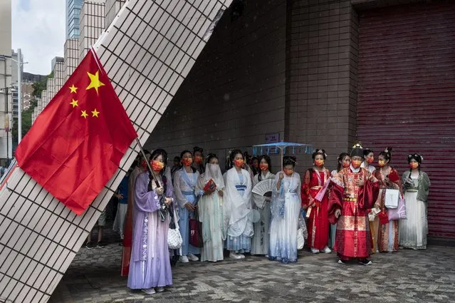 People dressed in Han dynasty costumes take refuge from rain during China's National Day in Hong Kong, China, 01 October 2022. China celebrates its National Day on 01 October 2022, marking the 73rd founding anniversary of the People's Republic of China. (Photo by Miguel Candela/EPA/EFE)