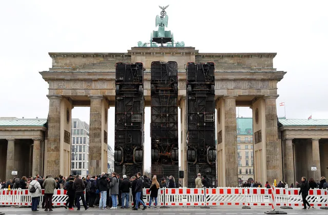 An installation “Monument” by German-Syrian artist Manaf Halbouni stands in front the Brandenburg Gate in Berlin, Germany, November 10, 2017. The installation, previously displayed in Dresden, displays three upended buses to mimic a defensive barricade erected in Aleppo, in Syria, to protect people from sniper fire. (Photo by Fabrizio Bensch/Reuters)