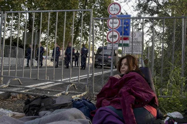 A migrant sits in front of a fence as she waits to enter Hungary, after the Hungarian police sealed the border with Serbia, near the village of Horgos, Serbia, September 15, 2015. (Photo by Marko Djurica/Reuters)