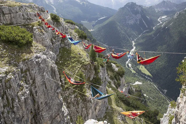 Doesn’t taking a nap in a hammock outdoors sound lovely? Perhaps not when you’re hanging in the air, thousands of feet above ground, between two mountains in the Italian Alps! Which is exactly what these adventurous folks did during the International Highline Meeting in Monte Piana, Italy. (Photo by Sebastian Wahlhuetter Photography)