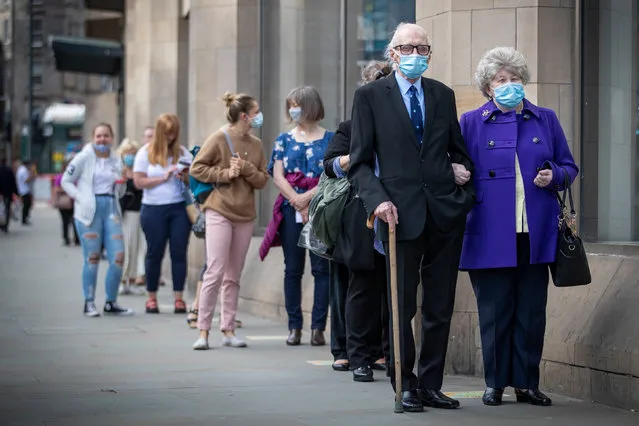 People queue outside the John Lewis department store in Edinburgh which re-opened its doors today, July 13, 2020, as Scotland prepares for the lifting of further coronavirus lockdown restrictions. (Photo by Jane Barlow/PA Images via Getty Images)