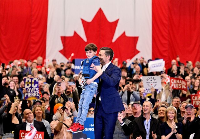 Conservative Party of Canada leader Pierre Poilievre lifts a child dressed in a police costume at a rally in Surrey, British Columbia, Canada on March 27, 2025. (Photo by Jennifer Gauthier/Reuters)