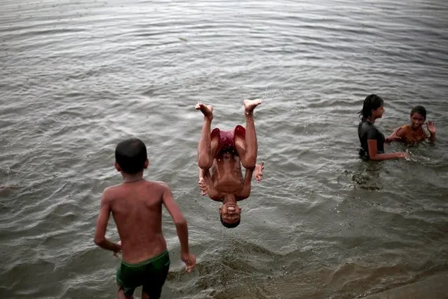 Boys dive at a lake amid the ongoing coronavirus lockdown in Kolkata, India, 05 August 2020. The West Bengal government announced a week-long complete lockdown in different areas around Kolkata and nearby districts amid a spike in infections. (Photo by Piyal Adhikary/EPA/EFE)