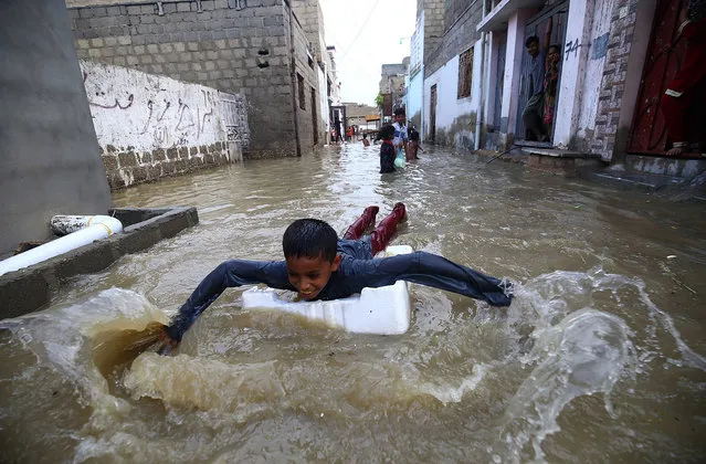 Children play in rain water after heavy rains in Karachi, Pakistan, 26 July 2020. (Photo by Shahzaib Akber/EPA/EFE)