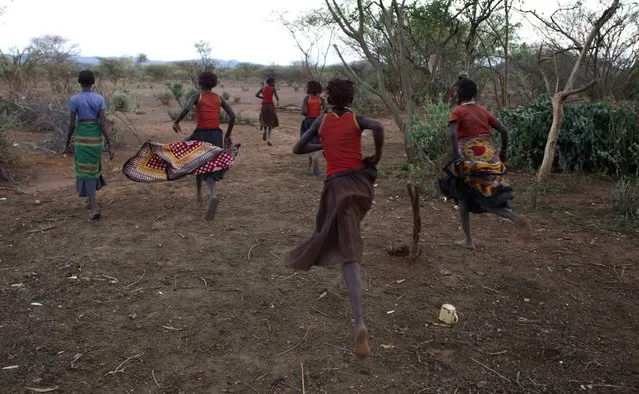 Pokot girls run from their hut and make their way to a place where they will take off their clothes and wash during their circumcision ceremony in a village about 80 kilometres from the town of Marigat in Baringo County, October 16, 2014. (Photo by Siegfried Modola/Reuters)