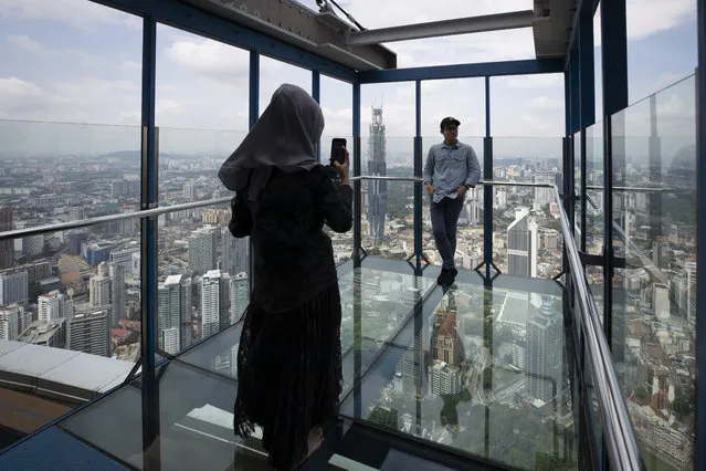 Tourists pose for photos at the Skybox at Kuala Lumpur Tower in Kuala Lumpur, Malaysia, Wednesday, July 1, 2020. Malaysia entered the Recovery Movement Control Order (RMCO) after three months of coronavirus restrictions. (Photo by Vincent Thian/AP Photo)