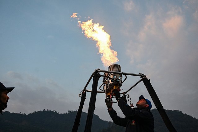 Participants prepare their hot-air balloon during the International Hot-Air Balloon festival in Pokhara on December 24, 2024. (Photo by Prakash Mathema/AFP Photo)
