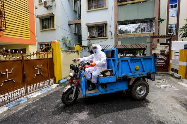 A civic staff in protective suit arrives to disinfect an apartment where one of the residents tested positive for COVID-19  in Kolkata, India, Tuesday, September 22, 2020. The nation of 1.3 billion people is expected to become the coronavirus pandemic's worst-hit country within weeks, surpassing the United States. (Photo by Bikas Das/AP Photo)