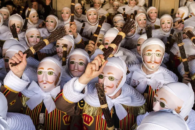 A group of people dressed as “Gilles of Binche”, arrive to pick up their jubilee medals at the City Hall on the Grand Place, during the Carnival of Binche, in Binche, Belgium, Tuesday, February 13, 2018. Up to 1,000 clown-like performers known as Gilles, appear in the city centre of Binche, wearing a hat covered with ostrich feathers and a red, yellow and black medieval costume decorated with bells and with lace at the neck, wrists and ankles. The Carnival of Binche is recognized by UNESCO as a masterpiece of the Oral and Intangible Heritage of Humanity. (Photo by Geert Vanden Wijngaert/AP Photo)