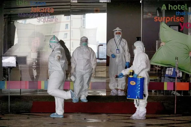 A medical worker sprays disinfectant onto a colleague at a hotel used as an isolation shelter in Jakarta, Indonesia, October 1, 2020. The COVID-19 cases in Indonesia rose by 4,174 within one day to 291,182, with the death toll adding by 116 to 10,856, the Health Ministry said on Thursday. (Photo by Chine Nouvelle/EPA/EFE/Rex Features/Shutterstock)