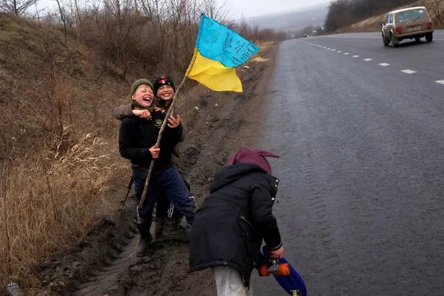 Children play along the side of the road, as Russia's attack on Ukraine continues, in Bakhmut, Ukraine on January 5, 2023. (Photo by Clodagh Kilcoyne/Reuters)