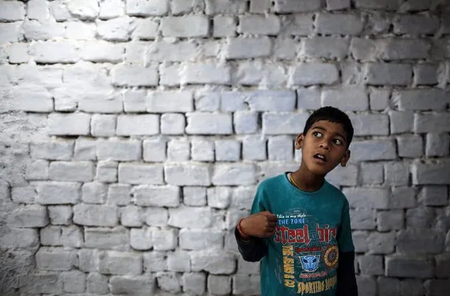 Eight-year-old Abhi, who suffers from mental and physical disabilities, plays outside his house at a slum in Bhopal November 15, 2014. Abhi receives treatment at a rehabilitation centre supported by Bhopal Medical Appeal which only treats families they believe have been affected by the Union Carbide gas leak 30 years ago. (Photo by Danish Siddiqui/Reuters)